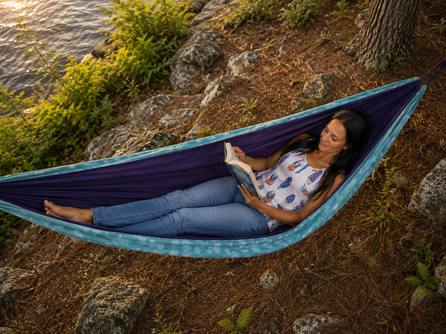 Overhead view of Kathy reading in the Azure Solstice hammock beside the lake