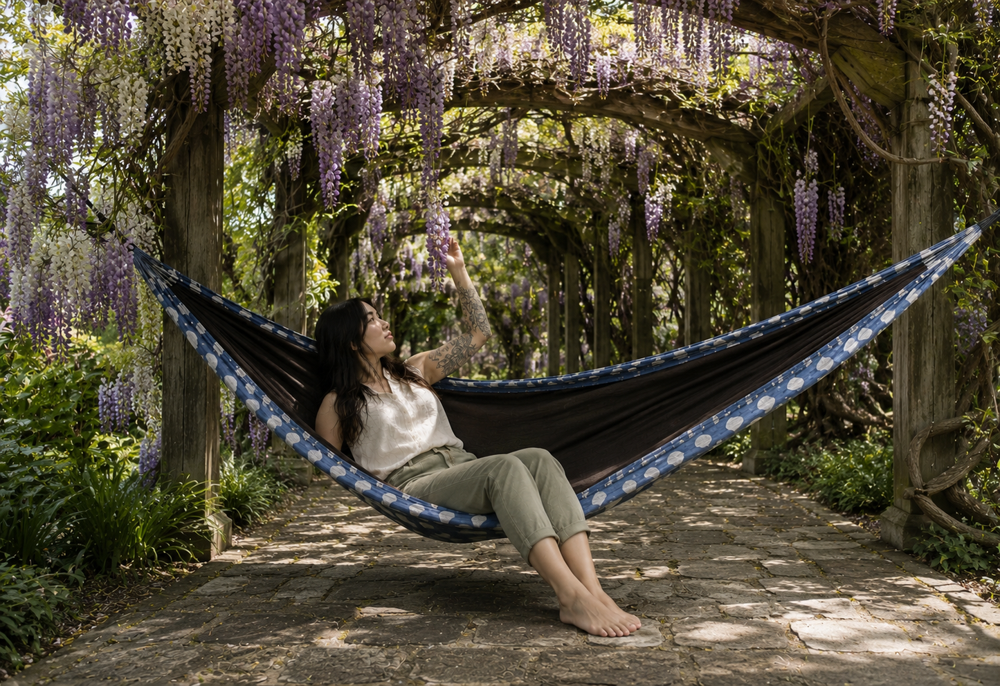 Botanica Solstice Premium Hammock beneath a flowering wisteria tunnel