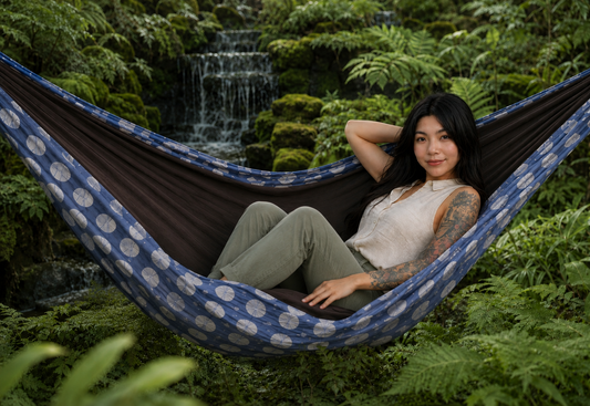 Botanica Solstice Premium Hammock with Minnie tucked comfortably inside beside a fern-grotto waterfall
