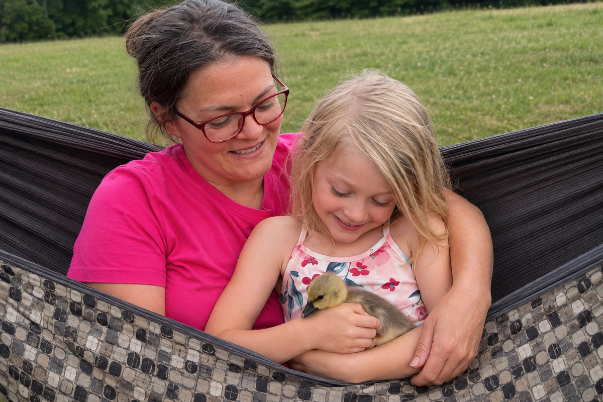 Mother and daughter cuddling a gosling in Chocoholic Premium Hammock