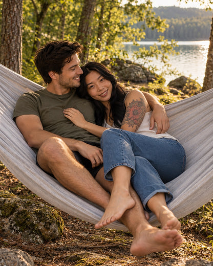 Couple cuddling in the extra-wide Concrete + Premium Hammock at golden hour