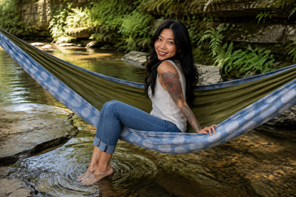 Woman smiling from Fernwater Solstice Premium Hammock with her feet by the water