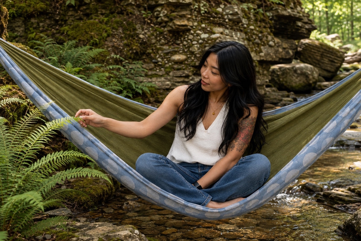 Woman admiring a fern from Fernwater Solstice Premium Hammock