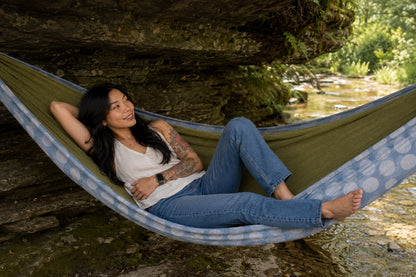 Woman resting quietly in Fernwater Solstice Premium Hammock beside the creek