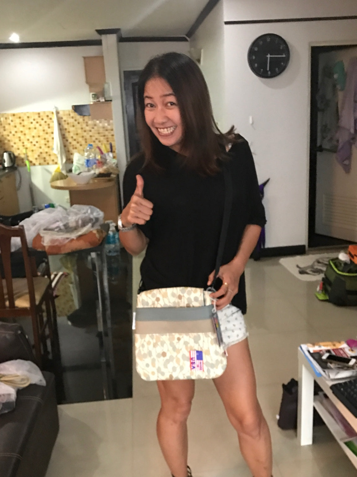 A smiling customer with a handmade Hammock Hut bag featuring a Made in USA tag.