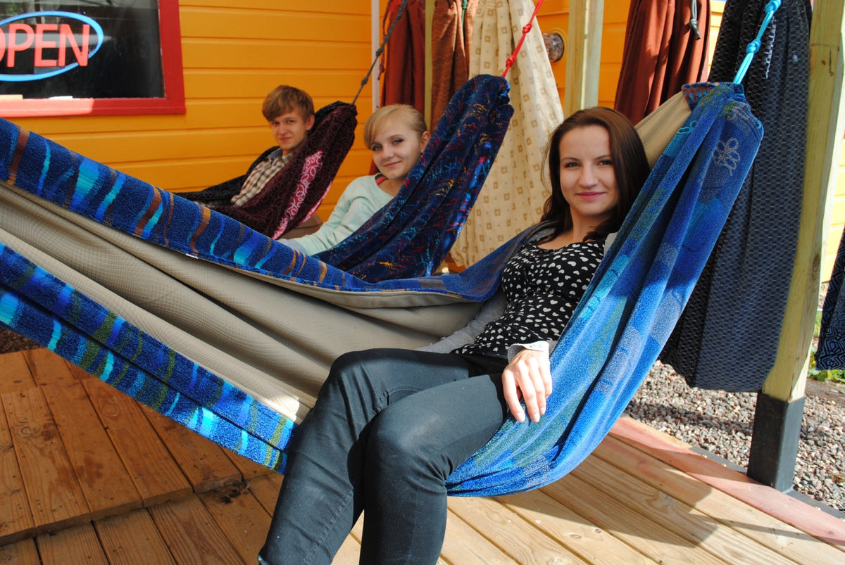 Friends enjoying colorful Hammock Hut hammocks outside the shop.