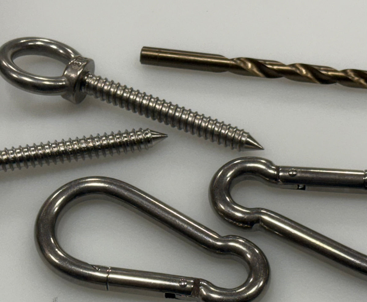 Close-up of stainless steel eye screw threads, carabiner and pilot bit