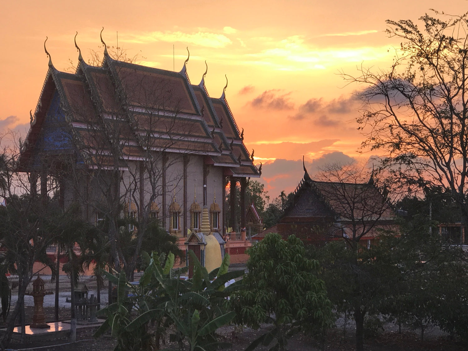 Sunset over a temple in Thailand, part of the Hammock Hut story