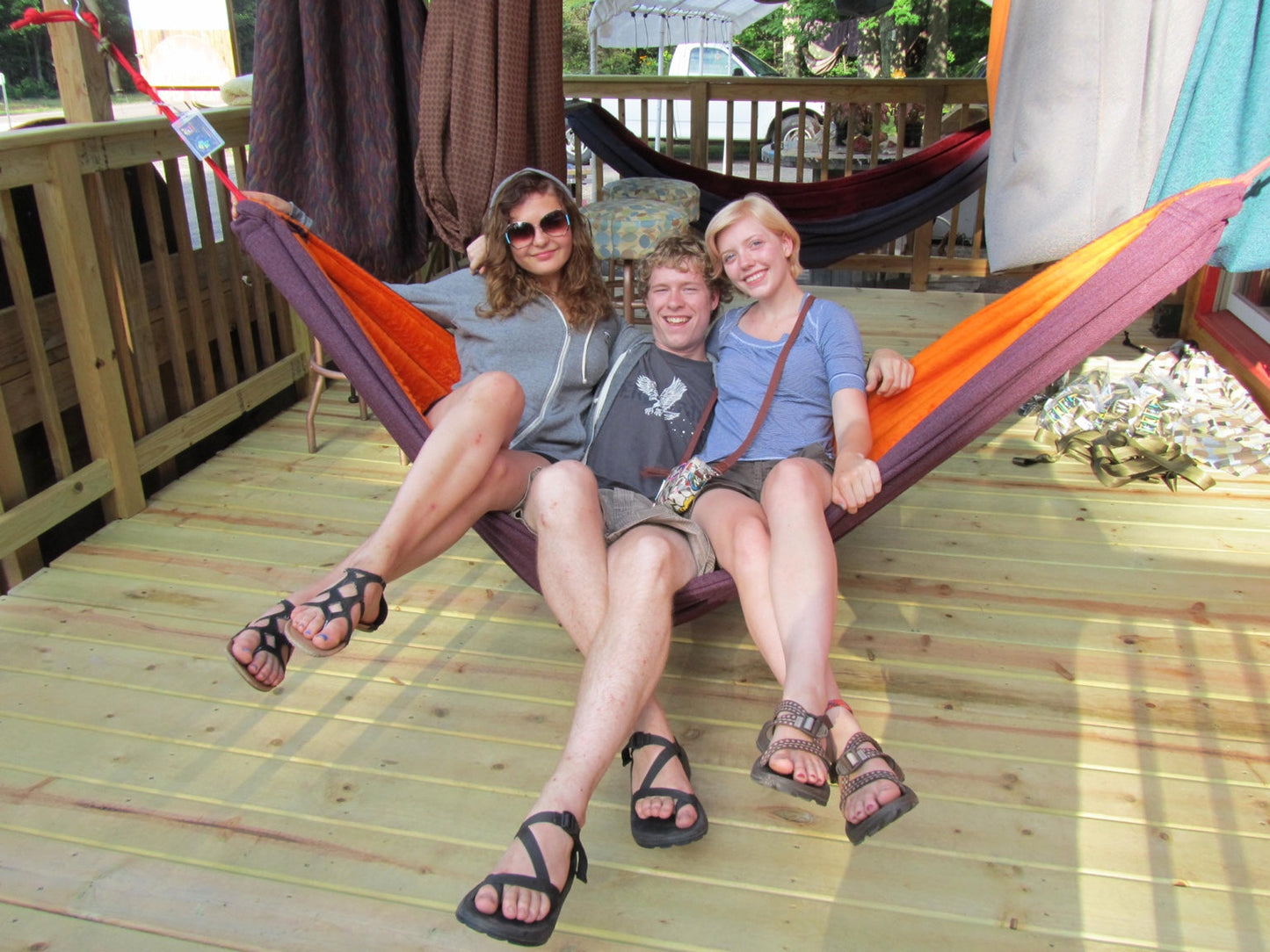 Three friends relaxing together in a handmade Hammock Hut hammock.