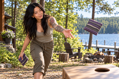 Mini Bo throwing a Premium Painted Stripe Purple cornhole bag by a Northwoods lake