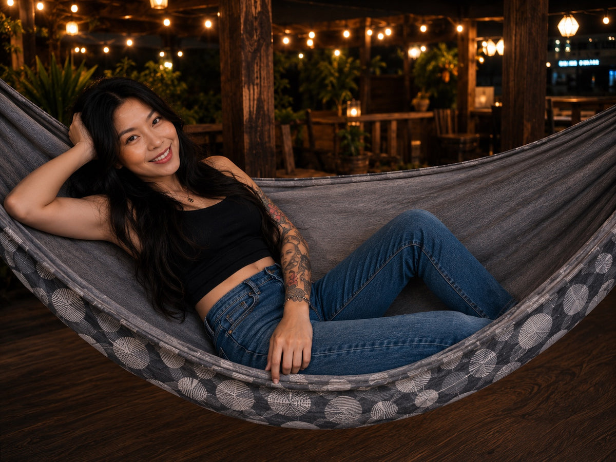 Moonstone Solstice Premium Hammock with model reclining comfortably under warm evening lights