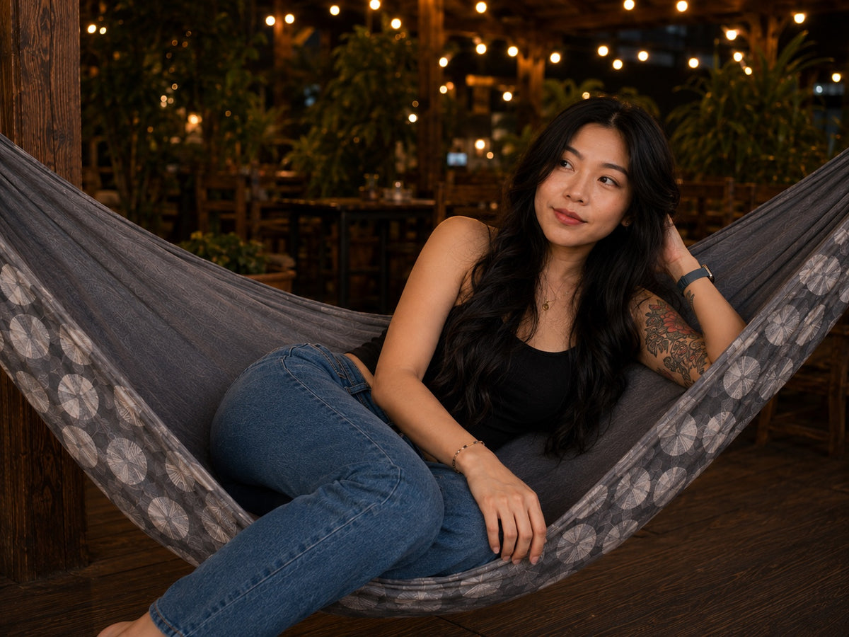 Moonstone Solstice Premium Hammock with model reclining and looking off to the side