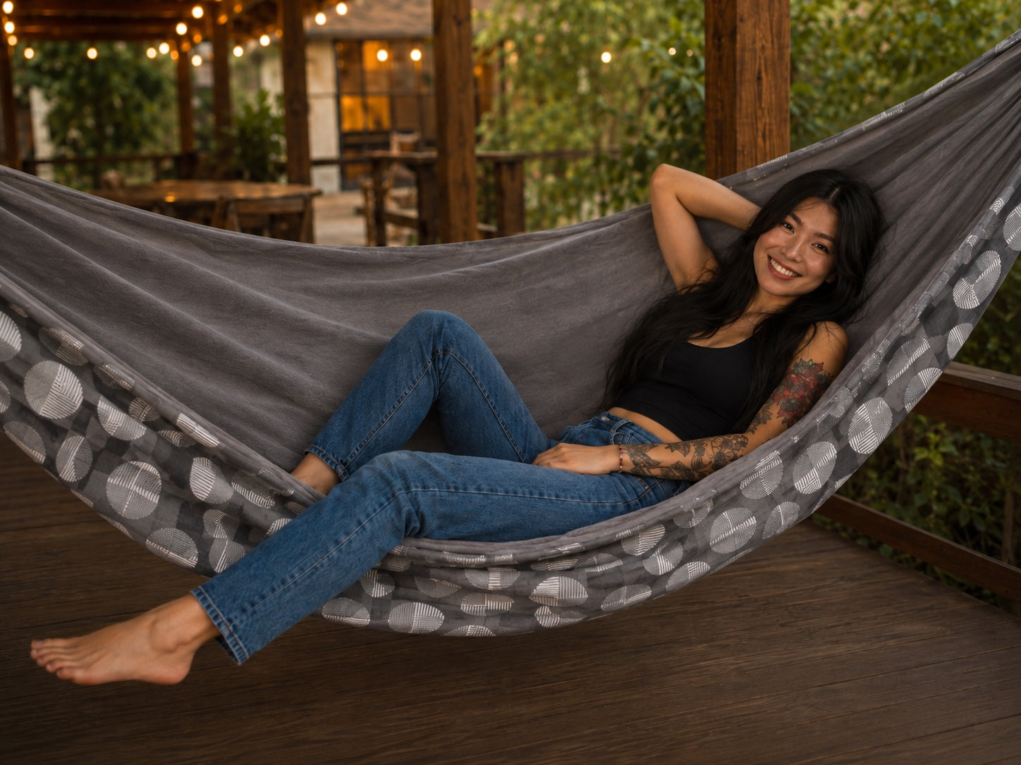Moonstone Solstice Premium Hammock with smiling model in a cozy outdoor setting