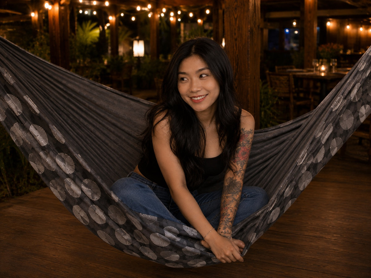 Moonstone Solstice Premium Hammock with model sitting cross-legged and smiling softly