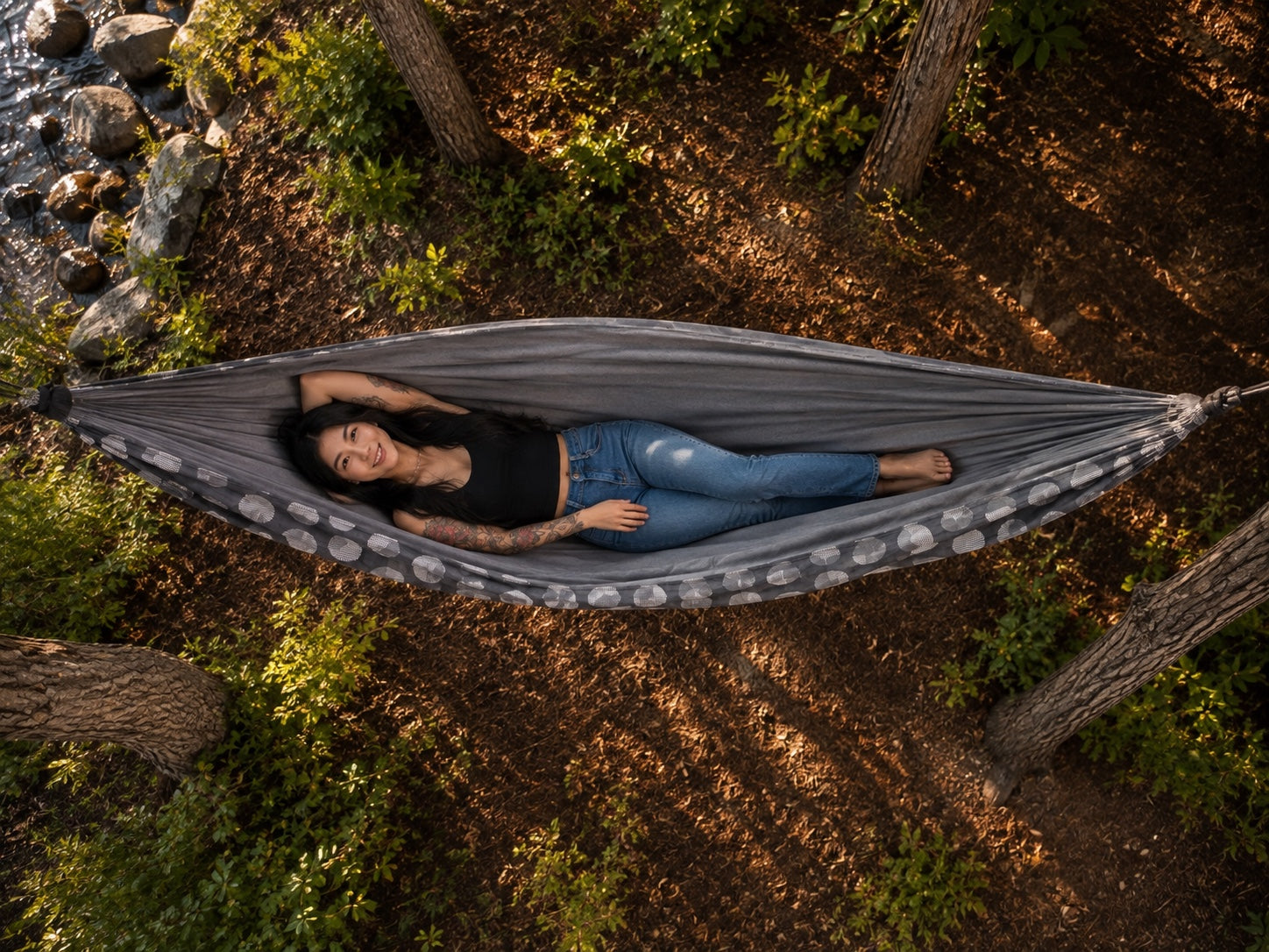 Aerial overhead view of the Moonstone Solstice Premium Hammock with model relaxing among trees