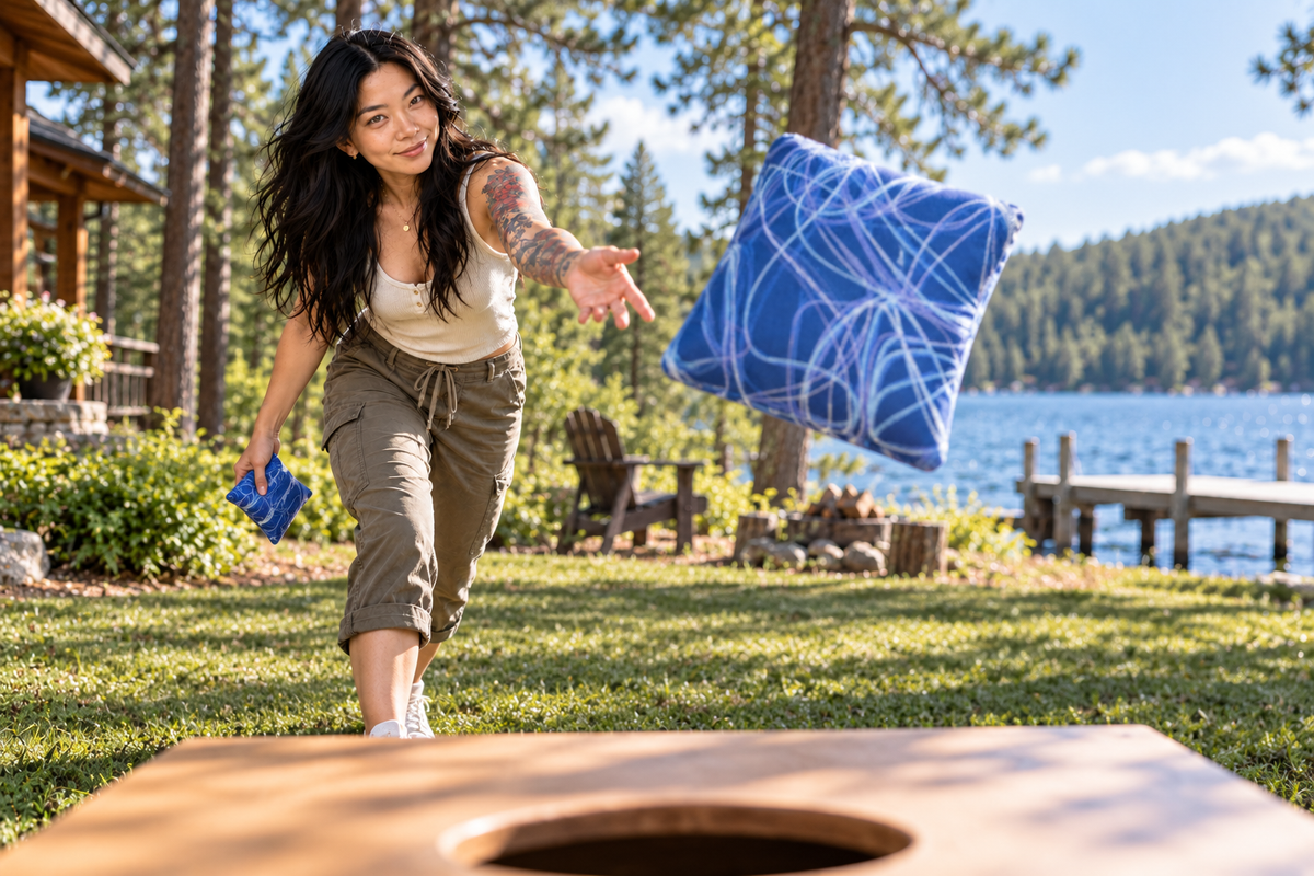 Mini Bo throwing a Premium Scribble Sapphire Blue cornhole bag by the lake
