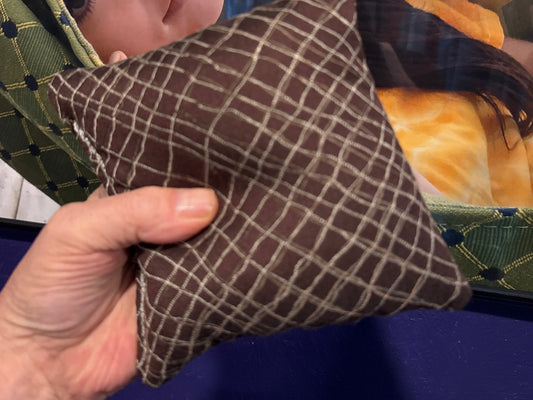 Spark Flow Mocha cornhole bag held in hand, landscape product photo