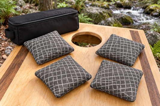 Four Spark Flow Titanium cornhole bags with matching patterned faces and black carrying case