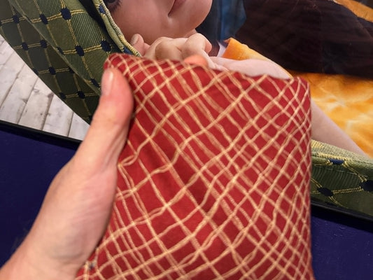 Spark Flow Habanero cornhole bag held in hand, landscape product photo